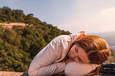 Young woman resting against landscape