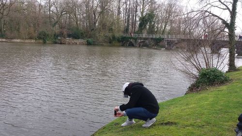 Rear view of woman with arms raised against trees
