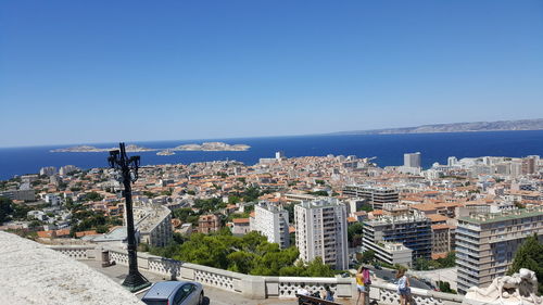 City at waterfront against blue sky