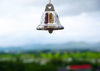 Low angle view of lighting equipment hanging against sky