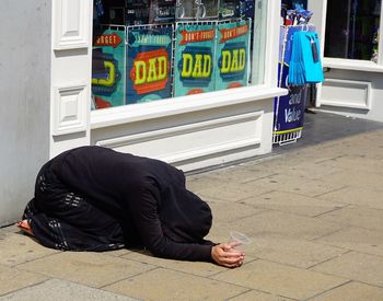 Woman begging on sidewalk