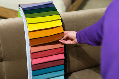 A women looks at tissue samples. selects the color of the sofa.