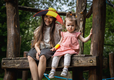 Portrait of two girls in a belgian flag hat in the park.