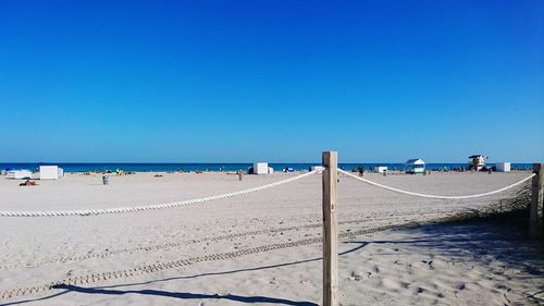 Scenic view of beach against clear blue sky