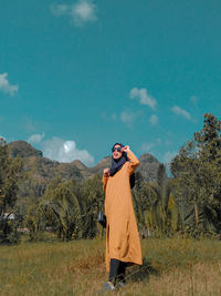 Full length of man standing on field against sky