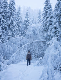 Man standing in a snow covered forest