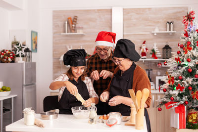 Family preparing food in kitchen during christmas