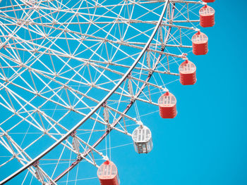 Low angle view of ferris wheel against blue sky