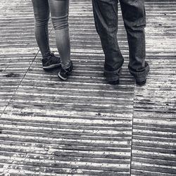 Low section of people walking on wooden footpath