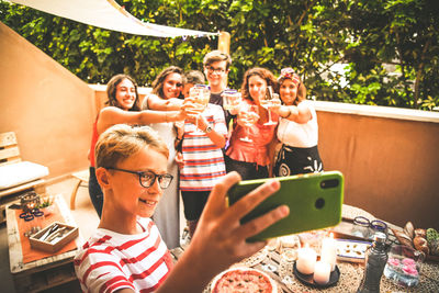 Boy taking selfie with family in balcony