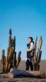 Woman standing and enjoying me time against clear blue sky 