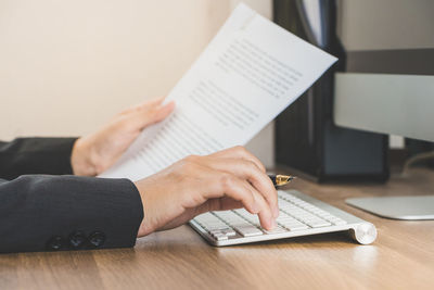 Midsection of woman using laptop on table