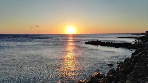 Scenic view of sea against clear sky during sunset