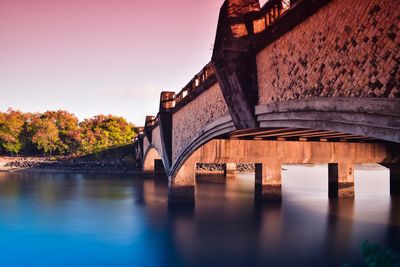 Arch bridge over river against buildings