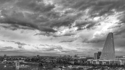 Buildings in city against cloudy sky