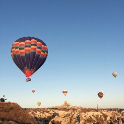 Low angle view of hot air balloons against clear sky on sunny day