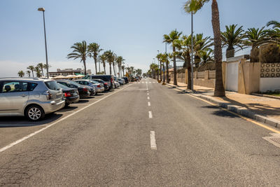 Cars on road in city against sky