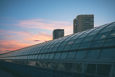Low angle view of modern buildings against sky during sunset