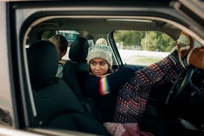 Mom sitting in car looking back at children looking curious