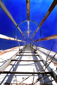 Low angle view of ladder against blue sky