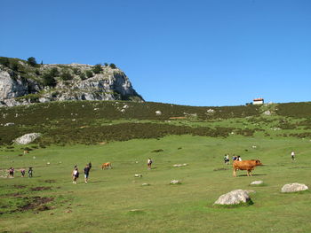 People walking on field against sky