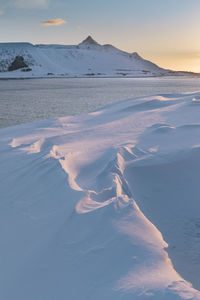 Aerial view of snowcapped mountain against sky during sunset