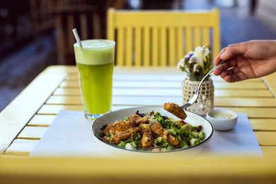 Cropped image of hand holding food on table