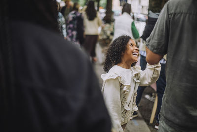 Cheerful daughter having fun with father at flea market