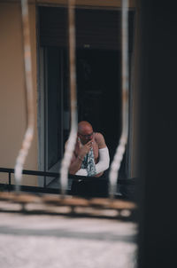 Portrait of man photographing through window