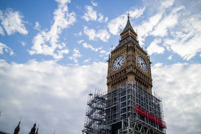 Low angle view of clock tower against cloudy sky