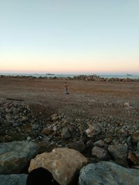 Man standing on rock against sky