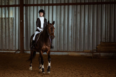 Full length portrait of young woman riding