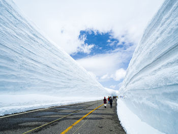 Road leading towards snowcapped mountain against sky