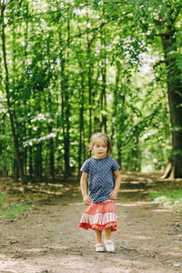 Full length of a girl standing in forest