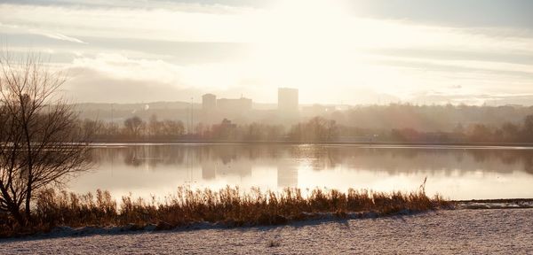 Scenic view of lake against sky at sunset