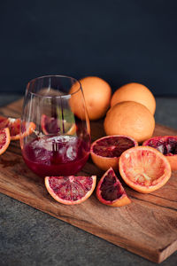Glass of fresh blood orange juice blood oranges on cutting board