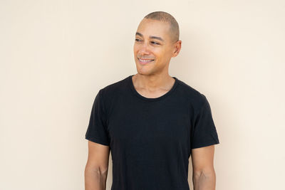 Portrait of young man standing against white background