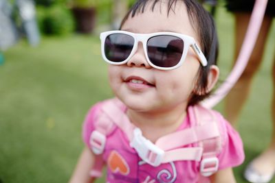 Close-up portrait of happy girl wearing sunglasses