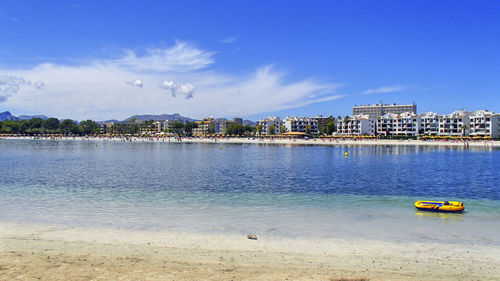 A yellow rubber inflatable yellow boat in the blue waters of the bay of alcudia on mallorca. 