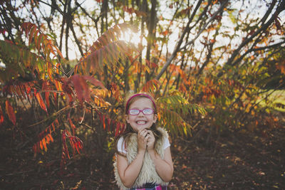 Portrait of smiling girl with leaves during autumn