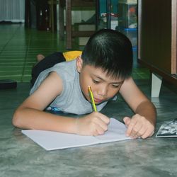 Boy drawing in book at home