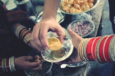 Cropped hand of woman taking panipuri from vendor