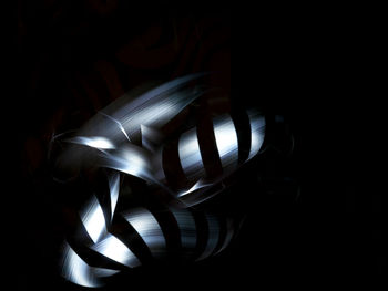 Close-up of illuminated lighting equipment against black background
