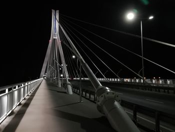 Illuminated suspension bridge against sky at night