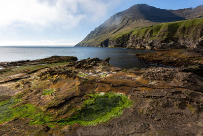 Scenic view of sea and mountains against sky