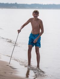 Portrait of shirtless man standing at beach