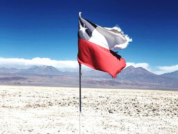 Flag on landscape against sky