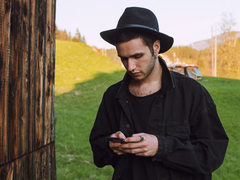 Man looking at camera while standing on mobile phone