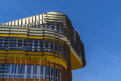 Low angle view of modern building against clear blue sky