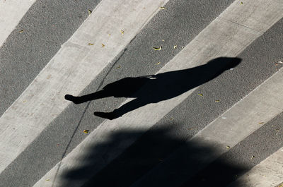 Shadow of person on pedestrian crossing 